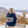 girl looking out at mountain in the winter wearing Hangover Hoodies Stupid Happy hoodie